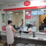 Customer depositing cash with secure banking services at Shires Post Office Leicester
